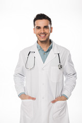 Wall Mural - Smiling doctor with stethoscope looking at camera isolated on white