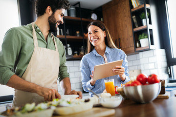 Wall Mural - happy couple cooking together in their kitchen