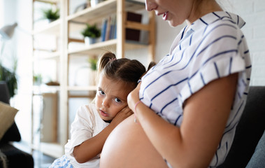 Poster - Beautiful pregnant woman with cute daughter. Pregnancy, family, love concept.