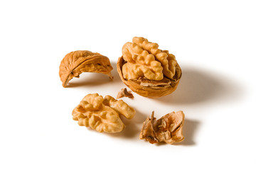 Still life with whole and shelled walnuts on a white background.