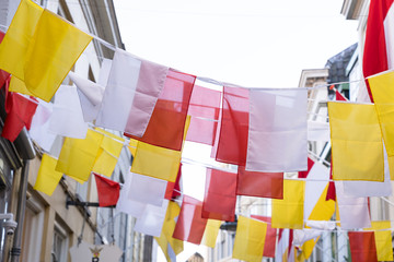 dutch square flags on a ribbon, in red, white and yellow, of traditional festival named carnaval, li