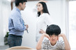 © Basicdog - Domestic problem in family., An Asian boy uses his hands to cover his ears because he doesn't want to hear the parents quarrel.