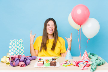 Sticker - Young caucasian woman organizing a birthday showing rock gesture with fingers