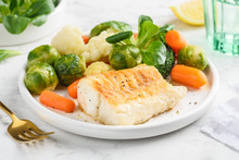 Fried Cod Fillet With Vegetables: Baby Carrots, Brussels Sprouts, Broccoli, Cauliflower And Corn Salad On A White Plate. Healthy Food. Selective Focus