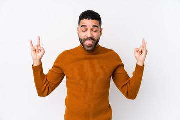 Wall Mural - Young latin man against a white background isolated showing rock gesture with fingers