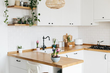 Modern White U-shaped Kitchen In Scandinavian Style. Spring Decoration Spring Flowers