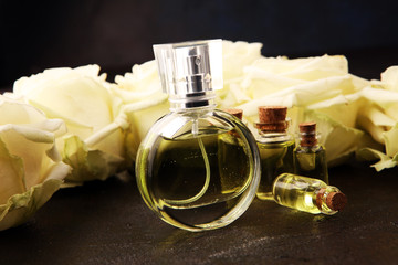 Bottle of perfume with flowers on rustic background. Aroma scent wellness concept