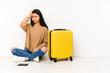 © Asier - Young chinese traveler woman sittting on the floor with a suitcase isolated being shocked, she has remembered important meeting.