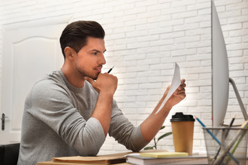 Canvas Print - Man working with document at table in office