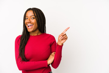 Young african american woman isolated smiling cheerfully pointing with forefinger away.