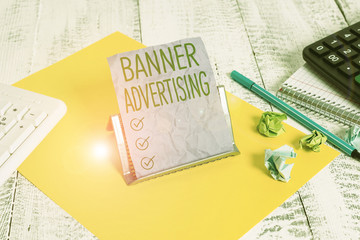 Handwriting text Banner Advertising. Conceptual photo advertisement that appears across the top of a web page Notepaper stand on buffer wire in between computer keyboard and math sheets