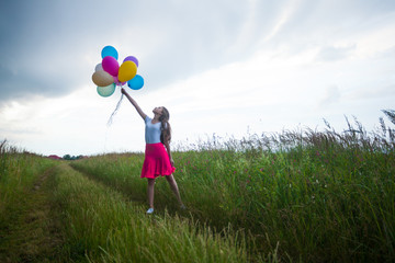 Storm in the field and teenage girl with balloons