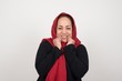 © Jihan - Portrait of young cute muslim woman being overwhelmed with emotions, expressing excitement and happiness with closed eyes and hands near face while smiling broadly over gray background.