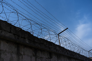 Barbed wire under electricity above the fence