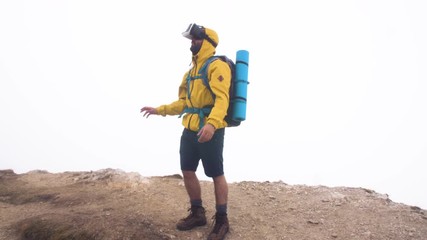 Wall Mural - vr virtual reality headset. young man hiker moving hands on cloudy sky and fog background. yellow ho