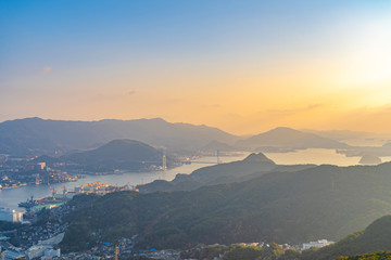 Wall Mural - Nagasaki cityscape panorama view from Mt Inasa observation platform deck in sunny day sunset time with blue sky background, famous beauty scenic spot in the world. Nagasaki Prefecture, Japan