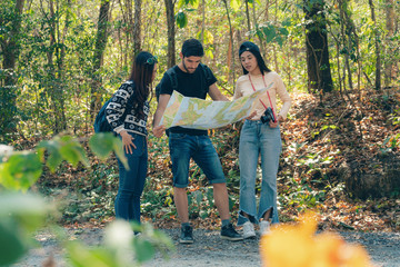 Wall Mural - diverse caucasian and asian friend having fun on traveling in natural park and seeing map for travel route