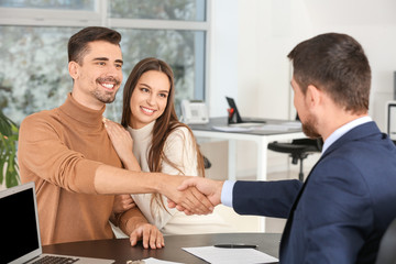 Canvas Print - Bank manager shaking hands with couple in office