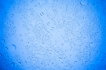 Rain droplets on blue glass background, Water drops on blue glass.