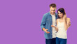 © vgstudio - Love, new parents and happy family concept - young happy couple, finding out results of a pregnancy test. Purple violet color background. Copy space for some text.