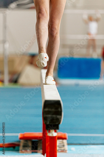 Fotomural girl gymnast point your toes on balance beam in gymnastics competition