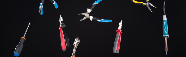 Wall Mural - Wrenches, screwdriver and pliers levitating in air isolated on black, panoramic shot