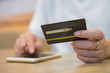 © manusapon - Hand holding credit card with shopping online. Online payment concept.