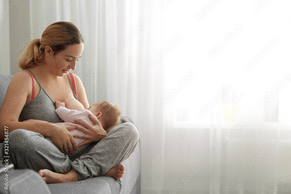 Young woman breastfeeding her baby at home. Space for text - obrazy, fototapety, plakaty 