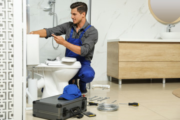 Wall Mural - Professional plumber working with toilet bowl in bathroom