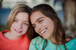 © NatBud - Two smiling girls. Two friends. Happy female students having fun together. Two young girls in the evening outside