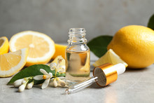 Citrus Essential Oil, Flower And Lemons On Light Table