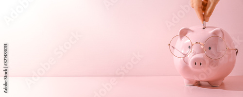 Fotomural Female finger putting a coin into piggy bank