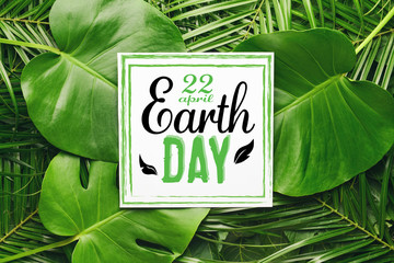 Card with green tropical leaves. Earth Day celebration