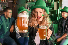 Young Woman With Beer Celebrating St. Patrick's Day In Pub