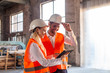 © oksix - Business people in protection helmet and jacket discussing a new construction project