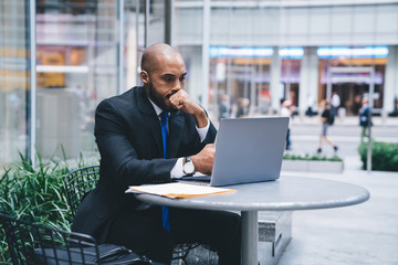 Wall Mural - Stressed African American businessman working on laptop