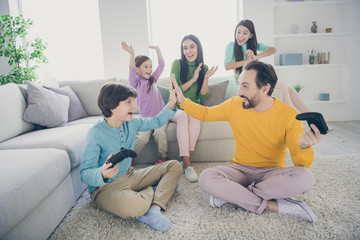 Sticker - Portrait of nice attractive glad big full cheerful cheery family pre-teen kids playing video game having fun celebrating winning contest at light white interior style house apartment living-room