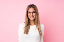 Young Blonde Woman Over Isolated Pink Background With Glasses