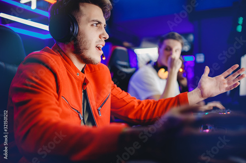 Fotografía Gamer young man is defeated in online video game, anger and facepalm, screaming and emotion, neon color