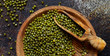 Dried mung beans with a spoon on a dark background