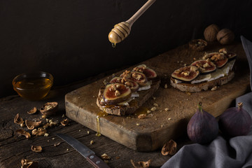 Wall Mural - Figs. Sandwiches with figs, cheese, arugula, honey and nuts. toast with creamy yogurt and feta cheese spread, fresh figs with honey. Bruschetta with cheese and figs. Homemade. Everyday autumn kitchen.