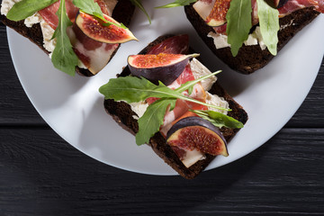 Wall Mural - Figs. Sandwiches with figs, cheese, arugula, honey and nuts. toast with creamy yogurt and feta cheese spread, fresh figs with honey. Bruschetta with cheese and figs. Homemade. Everyday autumn kitchen.