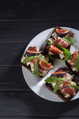 Wall Mural - Figs. Sandwiches with figs, cheese, arugula, honey and nuts. toast with creamy yogurt and feta cheese spread, fresh figs with honey. Bruschetta with cheese and figs. Homemade. Everyday autumn kitchen.