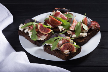 Wall Mural - Figs. Sandwiches with figs, cheese, arugula, honey and nuts. toast with creamy yogurt and feta cheese spread, fresh figs with honey. Bruschetta with cheese and figs. Homemade. Everyday autumn kitchen.