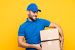 © luismolinero - Delivery man over isolated yellow background with happy expression