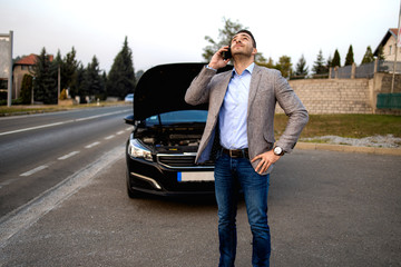 Desperate young man looking for a solution to a broken car