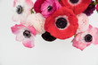 Pink blush and maroon ranunculus and anemone flowers flat lay