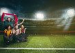 © alphaspirit - Soccer fans in the middle of the action during a night game at the stadium