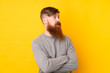 © luismolinero - Redhead man with long beard over isolated yellow background portrait