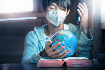 Poster - Close up hands of christian young man in mask, holding the globe and praying for peaple in the world, stop Disease Virus and War, christian concept.